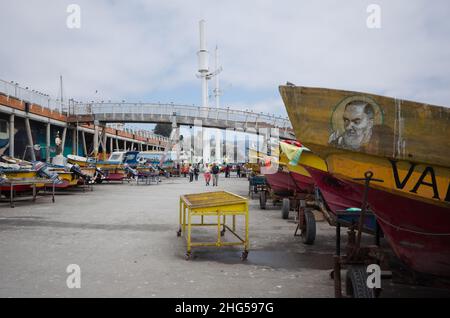 Valparaiso, Cile - Febbraio, 2020: I motoscafi sono parcheggiati vicino al mercato del pesce. Piccole imbarcazioni da pesca con motore su carrozze. Ritratto di san uomo sul lato Foto Stock