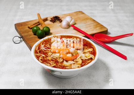 Sarawak Laksa con aglio crudo, limone. Un cibo popolare in Malesia vista dall'alto Foto Stock