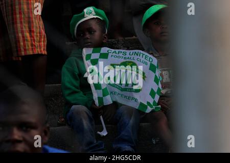 Un giovane ragazzo porta una bandiera del Caps United allo stadio Gwanzura di Highfield. CAPS United è una delle tre migliori squadre di calcio dello Zimbabwe. Zimbabwe. Foto Stock