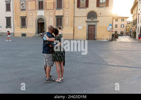 Pisa, Italia - 9 agosto 2021: Una coppia con uno smartphone che si fotografa in una piazza del centro storico Foto Stock