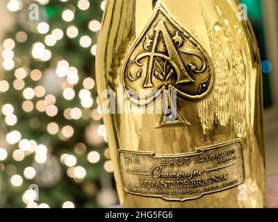 Armand de Brignac 'Ace of Spades' CHAMPAGNE raffinato e lussuoso, distintivo bottiglia di champagne in oro metallico con scintillanti luci da festa dietro Foto Stock