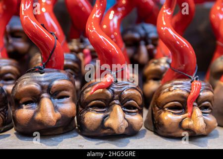 Napoli, Italia - 24 dicembre 2021: Oggetti superstiziosi composti da corna e mascherine tipiche napoletane, in vendita nelle bancarelle di San Gregorio Armeno, Foto Stock