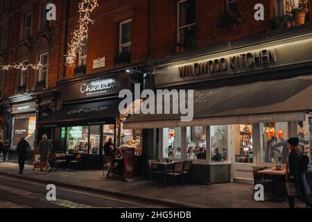 Londra, UK - 23 novembre 2021: Caffè e ristoranti in una strada a Covent Garden, una famosa area turistica di Londra con molti negozi e ristoranti Foto Stock