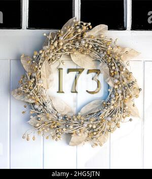 Tradizionale corona di natale appeso alla porta di fronte del 19th secolo cottage - Berkshire, Inghilterra, Regno Unito Foto Stock