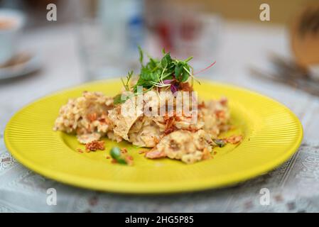 Purè di patate con crackling in un piatto giallo. Foto Stock