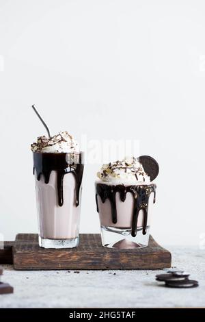Milkshake al cioccolato con panna montata e pezzi di biscotti con scaglie di cioccolato. Foto Stock