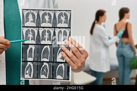 Pulmonologista che mostra TC scansione di polmoni femmina con polmonite su sfondo polmoni esame per paziente. Malattia polmonare, fibrosi polmonare Foto Stock