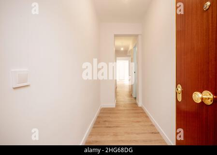 Porta d'ingresso color mogano per entrare in una casa con pannelli in rovere chiaro Foto Stock