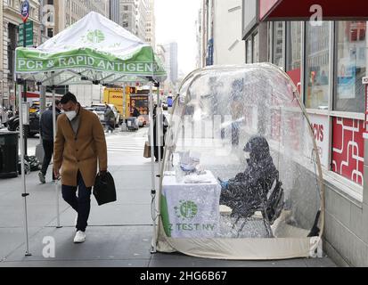 Un uomo passa davanti a un sito di test COVID-19 sul marciapiede di 5th Avenue martedì 18 gennaio 2022 a New York City. Foto di John Angelillo/UPI Foto Stock