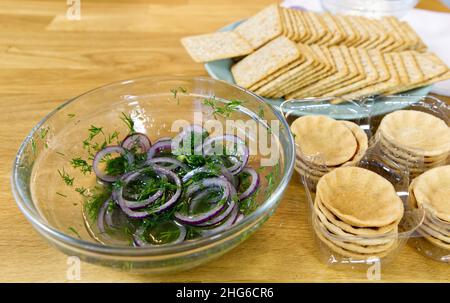 Il processo di preparazione di uno spuntino festivo su toast con spratti, cipolle, uova e pomodori. Foto Stock