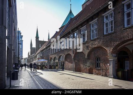 CLubeck, Germania, 15 gennaio 2022: Persone in controluce durante un viaggio di shopping e in una caffetteria di strada accanto al municipio storico nel centro della città, tour Foto Stock