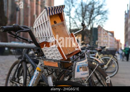 Lubeck, Germania, 15 gennaio 2022: Casa di nidificazione degli uccelli a forma di una tipica sedia da basket della germania settentrionale con posto per volantini, attaccata a un b Foto Stock