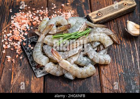 Gamberi crudi senza testa della tigre gamberi su un macellaio scissione. Sfondo di legno scuro. Vista dall'alto Foto Stock