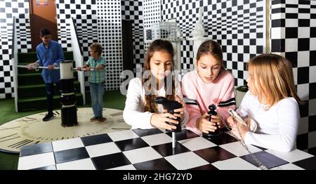 Avventura emozionante per i bambini positivi nella stanza di ricerca degli scacchi Foto Stock