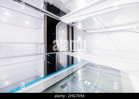 Interno di moderno frigorifero porta francese vuoto frigorifero con macchina fotografica punto di vista dall'interno pov con ripiani puliti primo piano Foto Stock