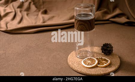 Svuotare l'acqua infusa con fette di arancia alle erbe essiccate. Foto Stock