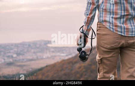 Donna viaggiatore si erge con binocolo e gode la natura. Foto Stock