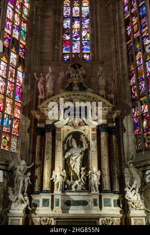 Altare laterale del Duomo di Milano, con magnifiche statue e vetrate. Foto Stock