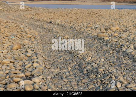 Strada in ghiaia sul lato del fiume Foto Stock