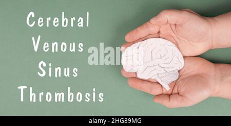 La trombosi venosa cerebrale del Sinus è in piedi su una carta, le mani che tengono un cervello, danno di vaccino, covid-19 Foto Stock