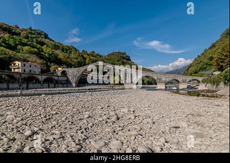 Grande quantità di pietre sul fondo del fiume Serchio, quasi secca nei pressi dell'antico Ponte della Maddalena, Lucca, Italia Foto Stock