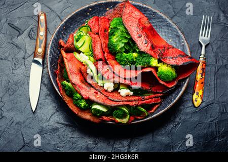 Piatto di frittelle di barbabietole farcite di verdure. Cibo sano Foto Stock