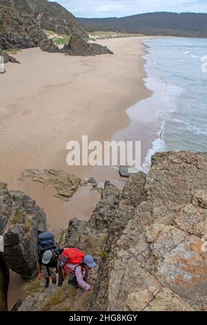 Escursionisti che salgono attraverso le scogliere sulla Baia di Moorina Foto Stock