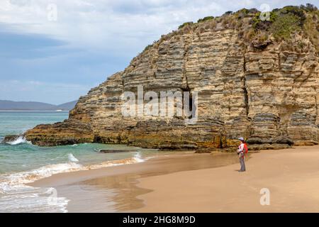 Donna su una spiaggia sulla Baia di Moorina, Isola di Bruny Foto Stock