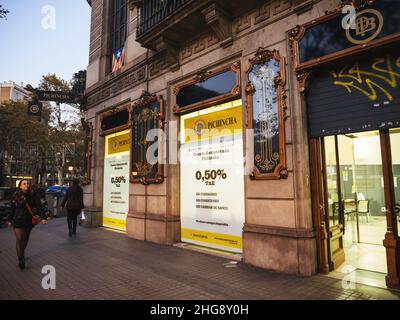 Barcellona, Spagna - Nov 14, 2017: Pedoni che camminano di fronte all'ingresso del Banco Pichincha al crepuscolo Foto Stock