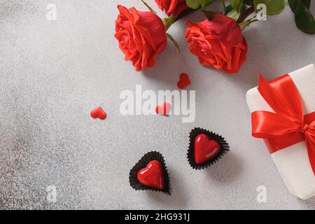 San Valentino due dolci al cioccolato a forma di cuore, regalo romantico, rose rosse. Vista dall'alto. Spazio di copia. Foto Stock