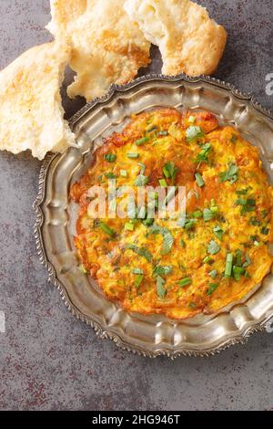 Masala Omelet in stile indiano famoso cibo di strada di Mumbai primo piano nel piatto sul tavolo. Vista dall'alto verticale Foto Stock