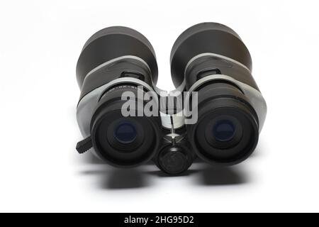 Primo piano di entrambe le lenti posteriori di grandi occhiali da campo binoculari neri su sfondo bianco come concetto per la vista e l'osservazione Foto Stock