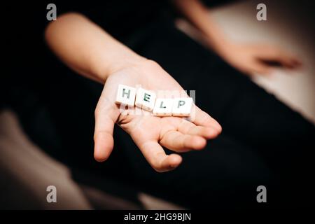 Ragazza che chiede aiuto. Ragazza allunga le mani con la parola aiuto nelle sue palme Foto Stock