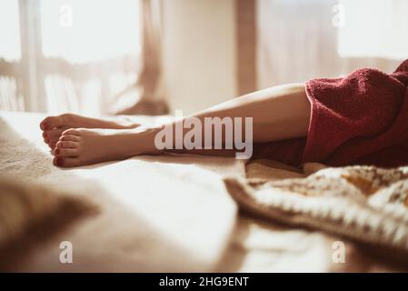 Primo piano di una donna gambe su un letto Foto Stock