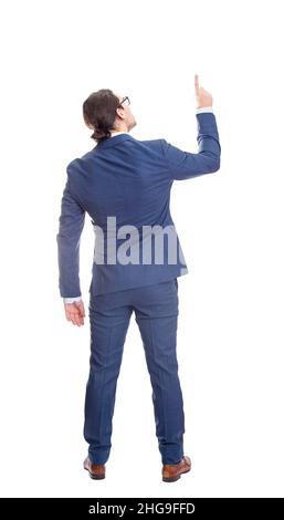 Vista posteriore uomo d'affari in tuta puntando indice dito, ritratto a tutta lunghezza isolato su sfondo bianco. Concetto di analisi aziendale Foto Stock
