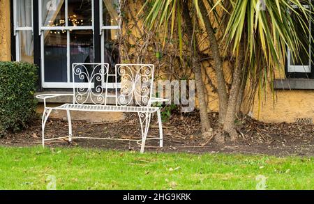 Panchine in metallo esposte in giardino per il relax Foto Stock