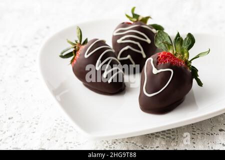 Fragole ricoperte di cioccolato con focalizzazione selettiva su quella di fronte. Foto Stock