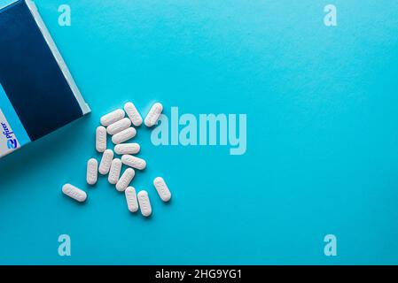 Izmir, Turchia - Novembre 5 2021: Pfizer Covid-19 Paxlovid scatola di trattamento e pillole isolate su uno sfondo blu. Foto Stock