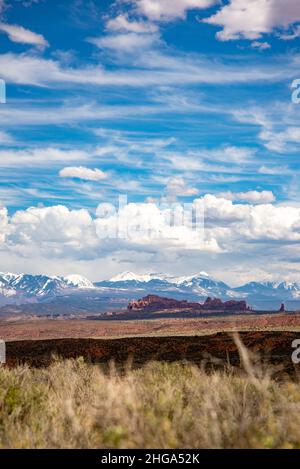 Un paesaggio all'Arches National Park dello Utah che mostra molti tipi di nubi e diversi biomei: Montagne, formazioni di arenaria, deserto e prateria. Foto Stock