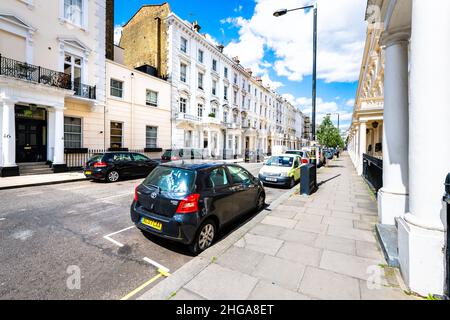 Londra, Regno Unito - 21 giugno 2018: Auto di parcheggio St George's Drive Street parcheggiate in Pimlico Road da terrazzamenti case balconi edifici e colonne in vi vecchio Foto Stock
