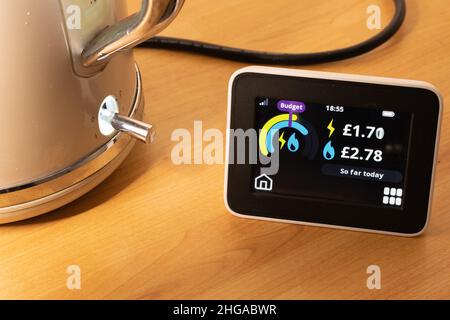 Display con indicatore intelligente che mostra il consumo di energia e il bollitore elettrico in fase di ebollizione. Usi finora oggi con benzina che eccede il preventivo. Foto Stock