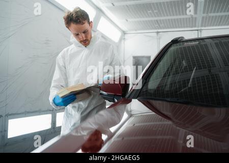 Il colorista automatico nella camera di verniciatura seleziona il colore della vernice per auto con campioni Foto Stock