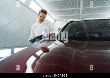 Il colorista automatico nella camera di verniciatura seleziona il colore della vernice per auto con campioni Foto Stock