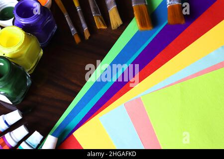 Attrezzature per arte e artigianato, opere d'arte, carta a colori, tubo colore, pennello, penna e coltello su sfondo nero Foto Stock