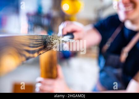 Carpentiere giovane che lavora con legno in officina Foto Stock