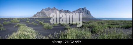 Spiaggia di lava nera, spiaggia sabbiosa, dune con erba secca, montagne Klipatindur, Eystrahorn e Kambhorn, punta Stokksnes, catena montuosa Klipatindur Foto Stock