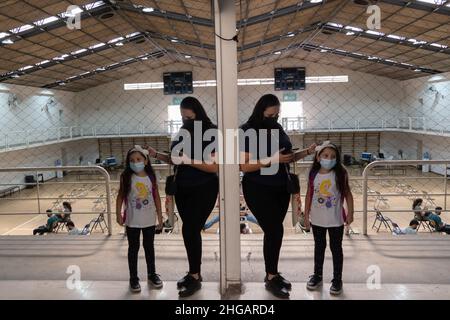 Santiago, Metropolitana, Cile. 19th Jan 2022. Una ragazza aspetta con la madre per ricevere il vaccino covido in un centro di vaccinazione a Santiago, Cile. Il paese ha già iniziato la vaccinazione con una quarta dose negli adulti più anziani, e le prime dosi nei bambini tra i 3 e i 5 anni. Mentre oggi il Cile ha registrato il suo numero record di infezioni giornaliere dall'inizio della pandemia, 9.509, e si prevede che aumenteranno molto di più nelle prossime settimane. (Credit Image: © Matias Basualdo/ZUMA Press Wire) Credit: ZUMA Press, Inc./Alamy Live News Foto Stock