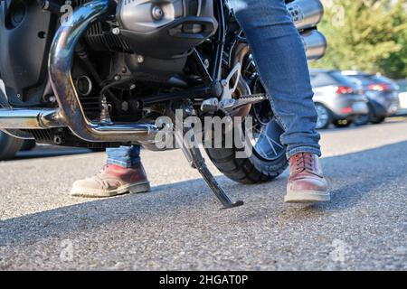 Vista ravvicinata del motociclista che posiziona il cavalletto Foto Stock