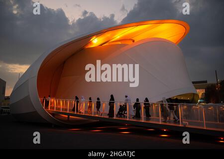 Futuristica chiocciola a forma di padiglione lussemburghese durante il tramonto con la gente islamica che cammina all'interno al Dubai Expo 2020 Foto Stock