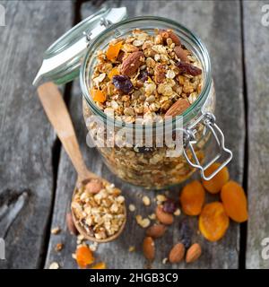 Granola nel vasetto di vetro sul tavolo di legno Foto Stock